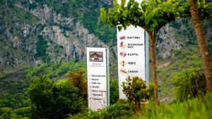 a sign in front of a mountain with trees at Gefiri Plakas Hotel by Konnect, Tzoumerka in Plaka