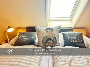 a bed with pillows with a picture of a man at Ferienwohnung mit Nordseeblick! de Swolk in Dorum Neufeld +16 photos