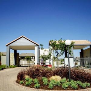 a building with a street light in a garden at Luxury Fourways Apartment, Pool, Gym and 24hr Security - Ventura Estate in Sandton