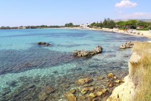 a beach with rocks in the water at Casa Deborah in Fontane Bianche
