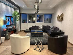 sala de estar con muebles en blanco y negro y TV en GT Loft - Haut de Gamme - Parking Gratuit - Moderne & Spacieux - Commerces à Proximité, en Bischheim