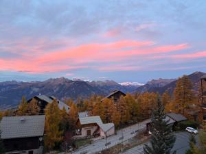 une vue d'une ville avec des montagnes en arrière-plan dans l'établissement Montagne, à Risoul 2 autres photos