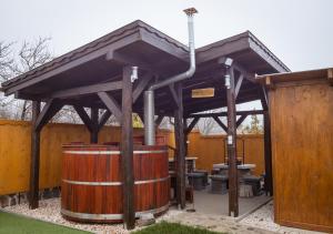 a wooden wine barrel under a wooden at Lebujos Vendégház in Boldogkőváralja