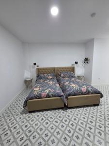 a bedroom with a bed with a patterned floor at Las Casitas de Jisa in Talavera de la Reina