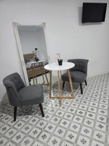 a room with two chairs and a table and a mirror at Las Casitas de Jisa in Talavera de la Reina