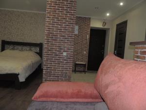 a bedroom with a bed and a brick wall at Academic apartment in Vinnytsya