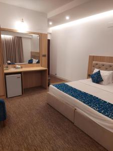 ein Hotelzimmer mit einem Bett, einem Waschbecken und einem Spiegel in der Unterkunft Laurel Lakefront Hotel in Dhaka + 33 Fotos