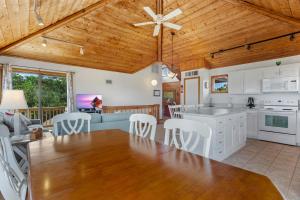 eine Küche und ein Wohnzimmer mit weißen Schränken und Holzdecken in der Unterkunft 1100 - La Maison De Geezer in Corolla
