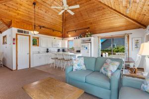 ein Wohnzimmer mit einer blauen Couch und einer Küche in der Unterkunft 1100 - La Maison De Geezer in Corolla