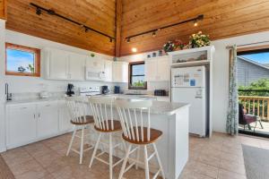 eine Küche mit weißen Schränken und Holzdecken in der Unterkunft 1100 - La Maison De Geezer in Corolla