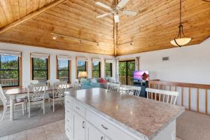 eine Küche und ein Wohnzimmer mit Tisch und Stühlen in der Unterkunft 1100 - La Maison De Geezer in Corolla + 27 Fotos