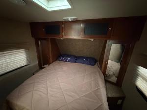 ein kleines Schlafzimmer mit einem Bett in einem kleinen Zimmer in der Unterkunft Camper Adventure in Livingston