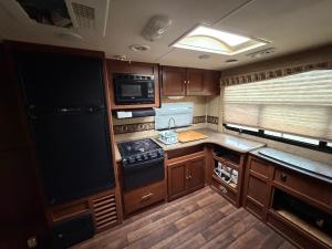 eine kleine Küche mit Herd und Mikrowelle in der Unterkunft Camper Adventure in Livingston