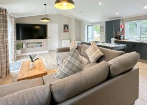 ein Wohnzimmer mit großer Couch und Küche in der Unterkunft Raywell Hall Country Lodges in Skidby + 24 Fotos