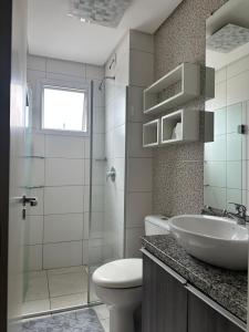 ein Badezimmer mit Waschbecken, Toilette und Dusche in der Unterkunft Ap Independecia in Santa Cruz do Sul