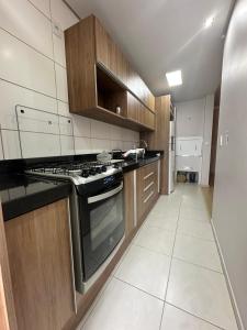eine Küche mit Holzschränken und einem Herd mit Backofen in der Unterkunft Ap Independecia in Santa Cruz do Sul + 1 Foto