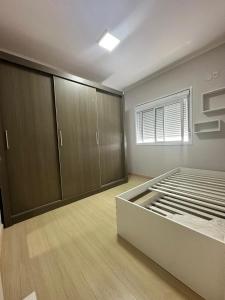 Großes Zimmer mit einem Bett und Holzschränken in der Unterkunft Ap Independecia in Santa Cruz do Sul