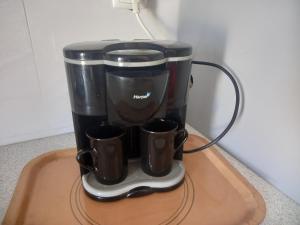 una cafetera en una bandeja con dos tazas en Casa Herminia, en Tarrafal