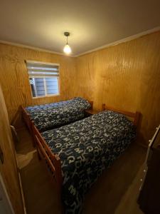 a small bedroom with a bed and a window at Casa Amayita in Puerto Varas
