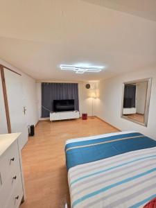 a living room with a bed and a flat screen tv at Hello Zimmer in Brügg