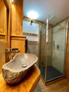 a bathroom with a stone sink and a shower at White Relax in Pila