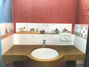 ein Badezimmer mit einem Waschbecken und einem Urinal in der Unterkunft Pousada Beija-Flor in Lavras Novas