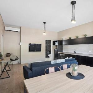 un salon avec un canapé bleu et une table dans l'établissement Park Lane Stay Leeton, à Leeton 3 autres photos