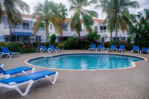 a swimming pool with blue lounge chairs and a hotel at Uncle Bobs Reef in Sabana Westpunt