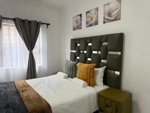 Un dormitorio con una cama grande y una ventana en Hippoville, en Mbabane