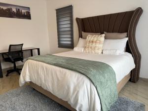 ein Schlafzimmer mit einem großen Bett und einer grünen Decke in der Unterkunft Hippoville in Mbabane