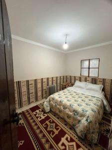 - une chambre avec un lit dans une pièce dotée d'un tapis dans l'établissement Maison authentique au cœur des oasis, à Ghardaïa