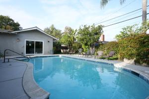a swimming pool with blue water in a yard at Destination #06 in Anaheim