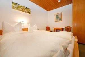 a bedroom with two beds with white sheets at Rundblick 2 Gartenwohnung in Tschagguns