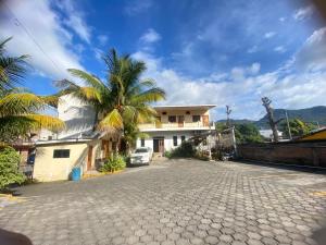 a house with a palm tree in front of a driveway at Hostal Casa Vieja in Matagalpa