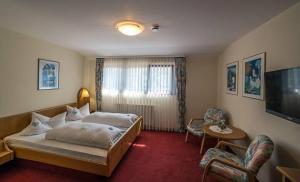 a hotel room with a bed and a television at Hotel Restaurant Freihof in Oberharmersbach +24 photos