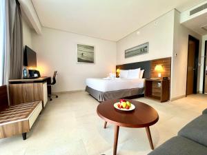 a hotel room with a bed and a bowl of fruit on a table at Fiesta Inn Express Cancún Cumbres in Cancún