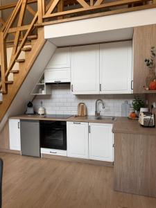a kitchen with white cabinets and a staircase at Polana House in Niedźwiada +14 photos