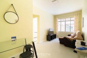 a living room with a couch and a table at Aptos completos com localização privilegiada no coração de Floripa – CSNs in Florianópolis +7 photos