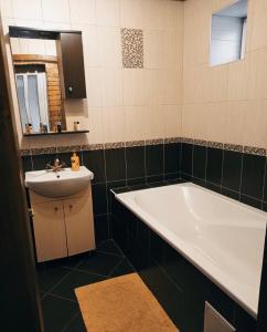 a bathroom with a bath tub and a sink at Золотий Ключик in Vyshka