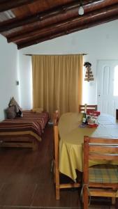 ein Zimmer mit einem Tisch und zwei Betten darin in der Unterkunft Los Peñi in Cortaderas