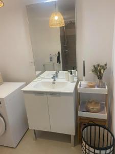 une salle de bain blanche avec un lavabo et un miroir dans l'établissement Entre Sable et Océan, appartement avec vue mer, à Fort-Mahon-Plage 23 autres photos