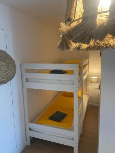 quelques lits superposés dans une chambre dans l'établissement Entre Sable et Océan, appartement avec vue mer, à Fort-Mahon-Plage