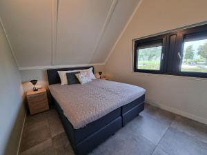 ein Schlafzimmer mit einem Bett und einem Fenster in der Unterkunft Water Villa in Balk with Private Jetty in Balk