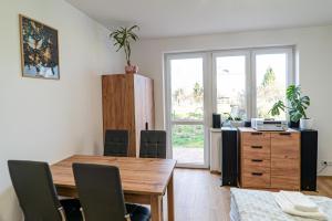 a dining room with a wooden table and chairs at Apartamenty Nad Wiarem in Przemyśl
