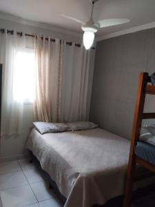 ein Schlafzimmer mit einem Bett und einem Fenster in der Unterkunft Apê Temporada Praia Grande SP Completo com Piscina, Churrasqueira, Estacionamento in Praia Grande + 37 Fotos