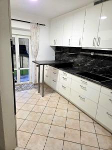 eine Küche mit weißen Schränken und einer schwarzen Arbeitsplatte in der Unterkunft Monteur-Haus Lübeck Berlin Pankow, Reinickendorf, Glienicke-Nordbahn 