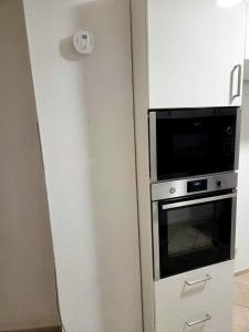 eine Küche mit Mikrowelle und Backofen in der Unterkunft Monteur-Haus Lübeck Berlin Pankow, Reinickendorf, Glienicke-Nordbahn 