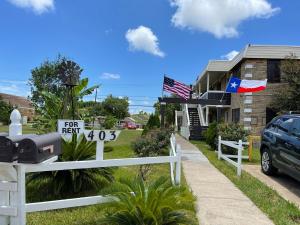 Ein „Zu vermieten“-Schild an einem weißen Zaun vor einem Haus in der Unterkunft Broadview Lovely Apt Close to Beaches in Freeport