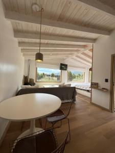 a living room with a white table and chairs at Cabaña El galpon - Villa Meliquina de Espacio Bandurrias - in Villa Meliquina