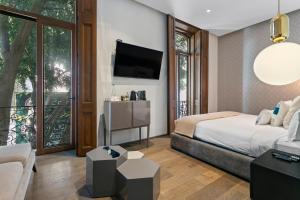 a bedroom with a bed and a tv on a wall at Casa Prim Hotel Boutique in Mexico City +136 photos